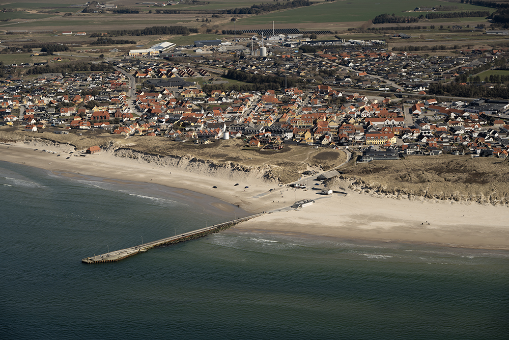 Molen ved Lkken med byen i baggrunden. Billedet er taget fra ssiden, og p billedet ses fiskekuttere der er trukket op p stranden, redningshuset og den centrale bydel